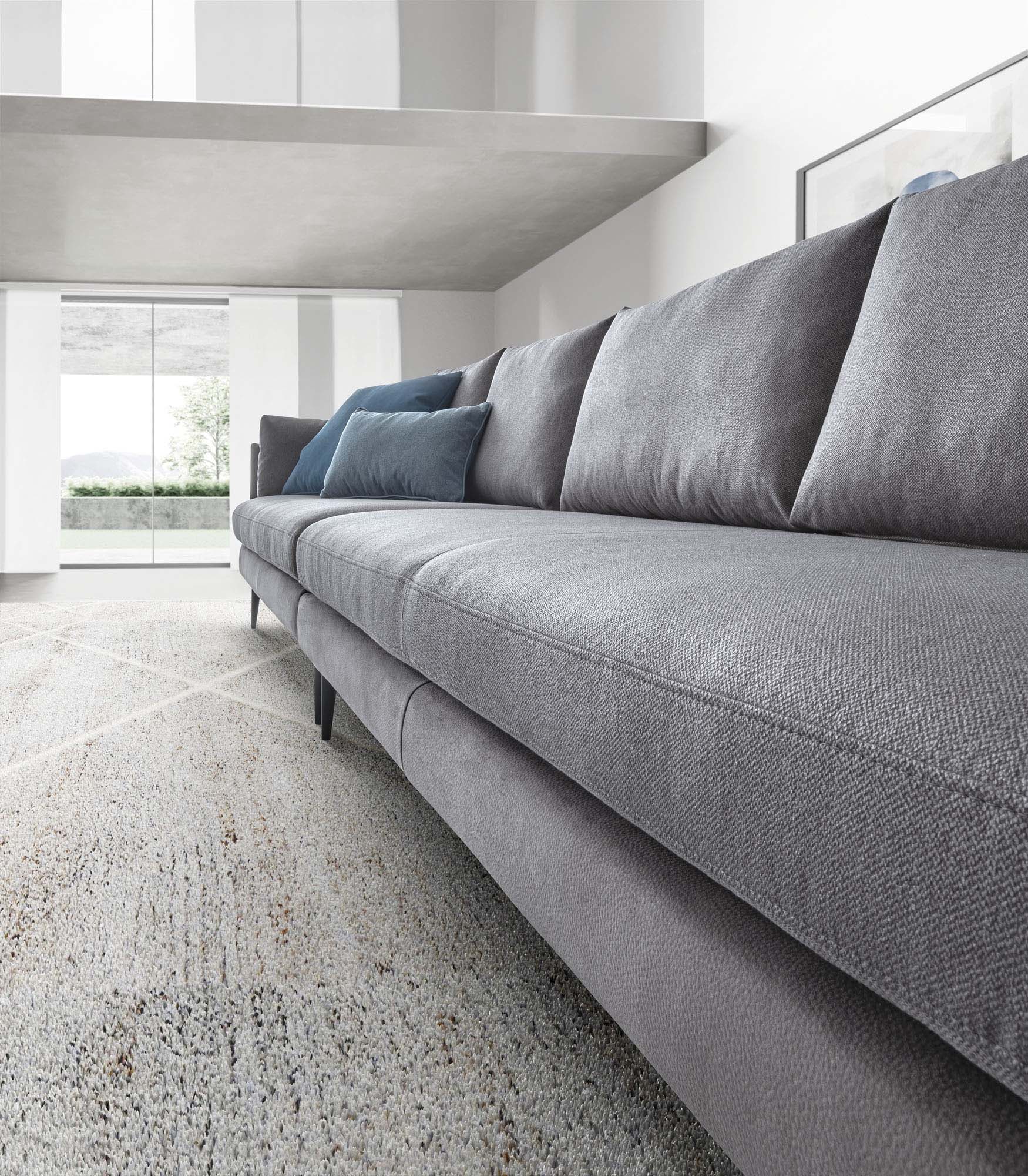 Divano grigio lineare con cuscini blu