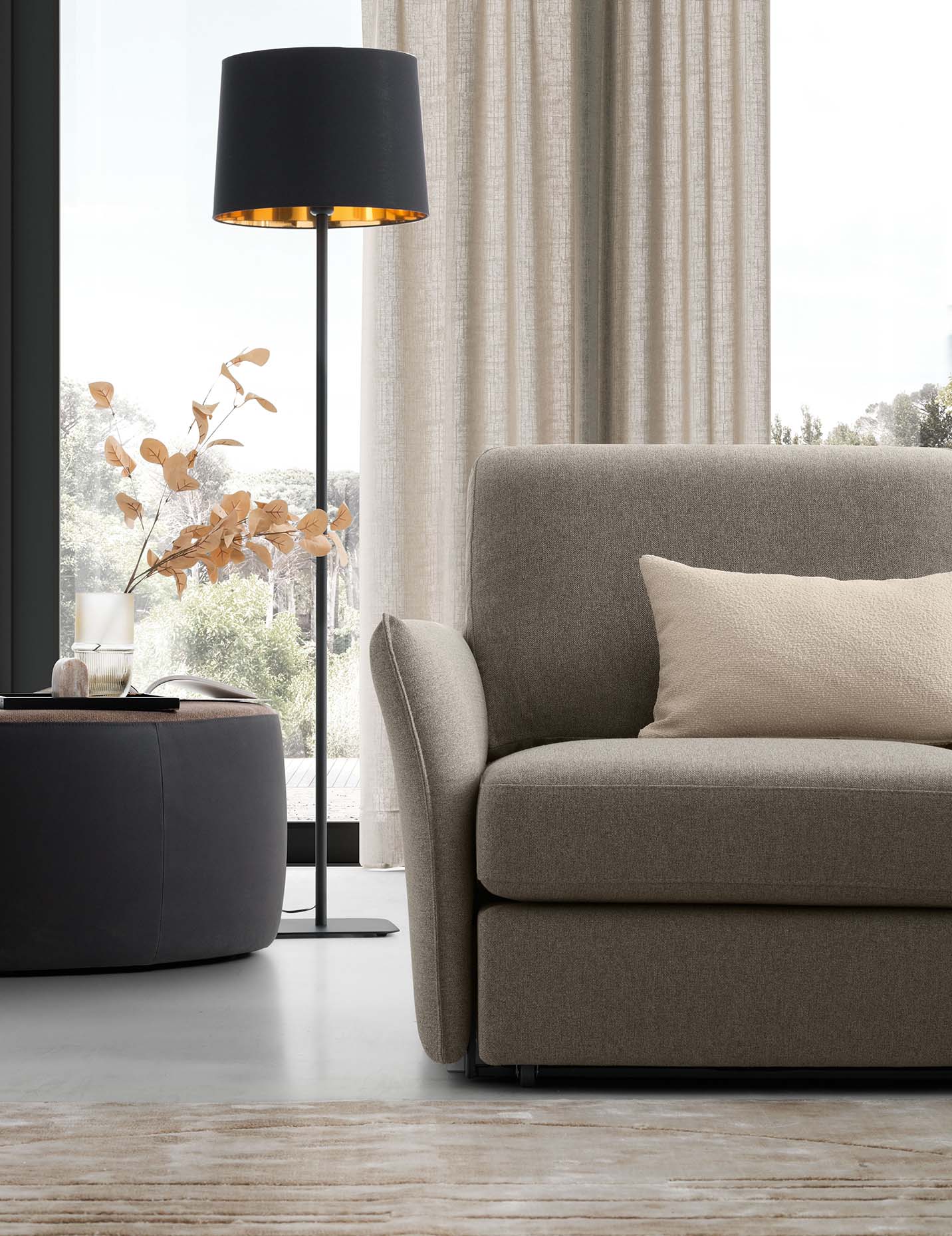 Seduta di un divano color grigio con bracciolo molto esile e salvaspazio e piedini molto bassi